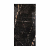 Black Daytona porcelain slab displayed on easel against luxury marble backdrop showing dramatic gold and white veining for UAE interior design