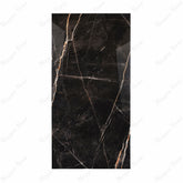 Black Daytona porcelain slab displayed on easel against luxury marble backdrop showing dramatic gold and white veining for UAE interior design