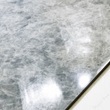 Close-up of Celest Onyx glossy porcelain tile showing mirror-polished icy grey surface with detailed crystalline texture and 9mm thickness
