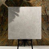 Close-up of Resina Grey matte porcelain tile showing detailed travertine texture, natural cracks, and 9mm thickness