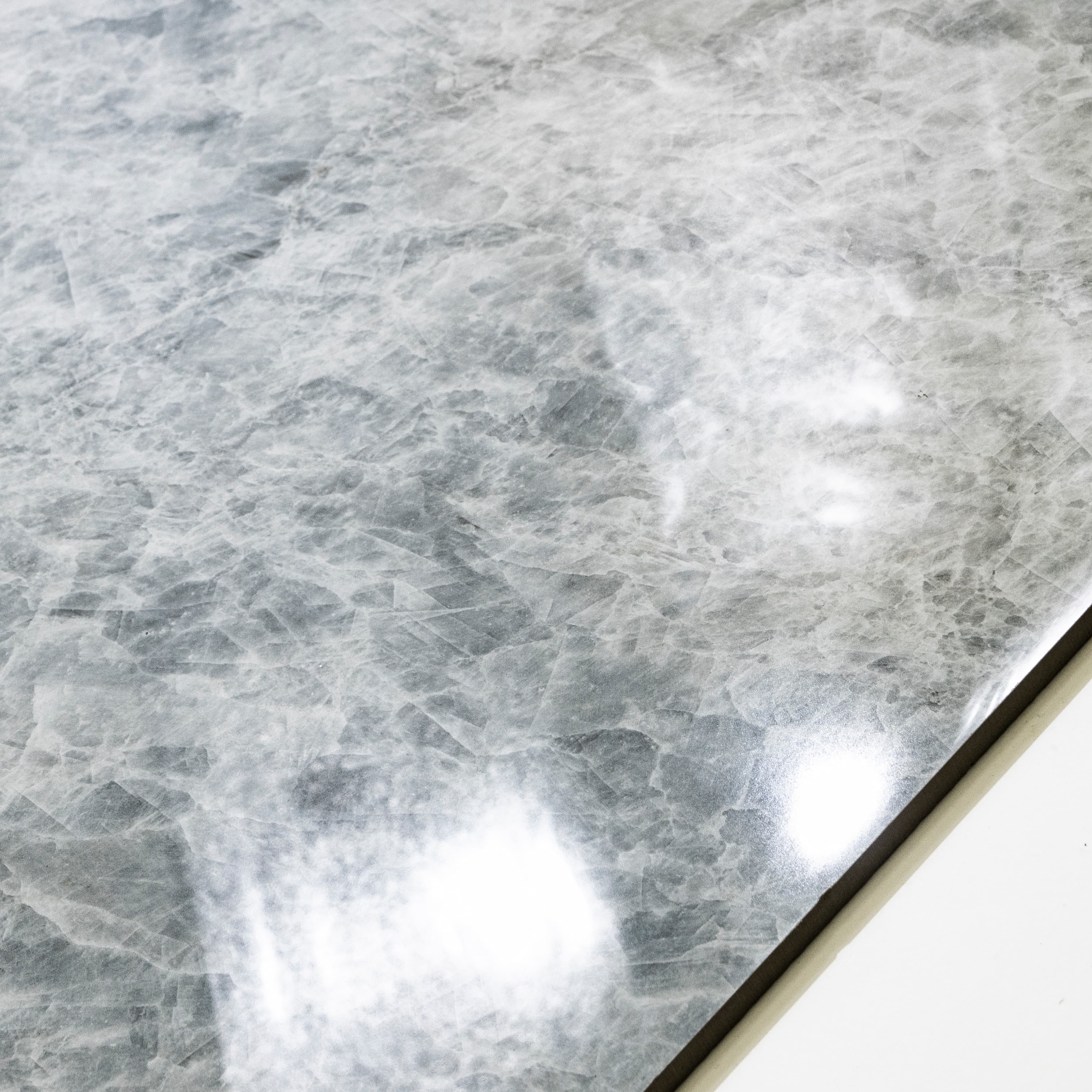 Close-up of Celest Onyx glossy porcelain tile showing mirror-polished icy grey surface with detailed crystalline texture and 9mm thickness