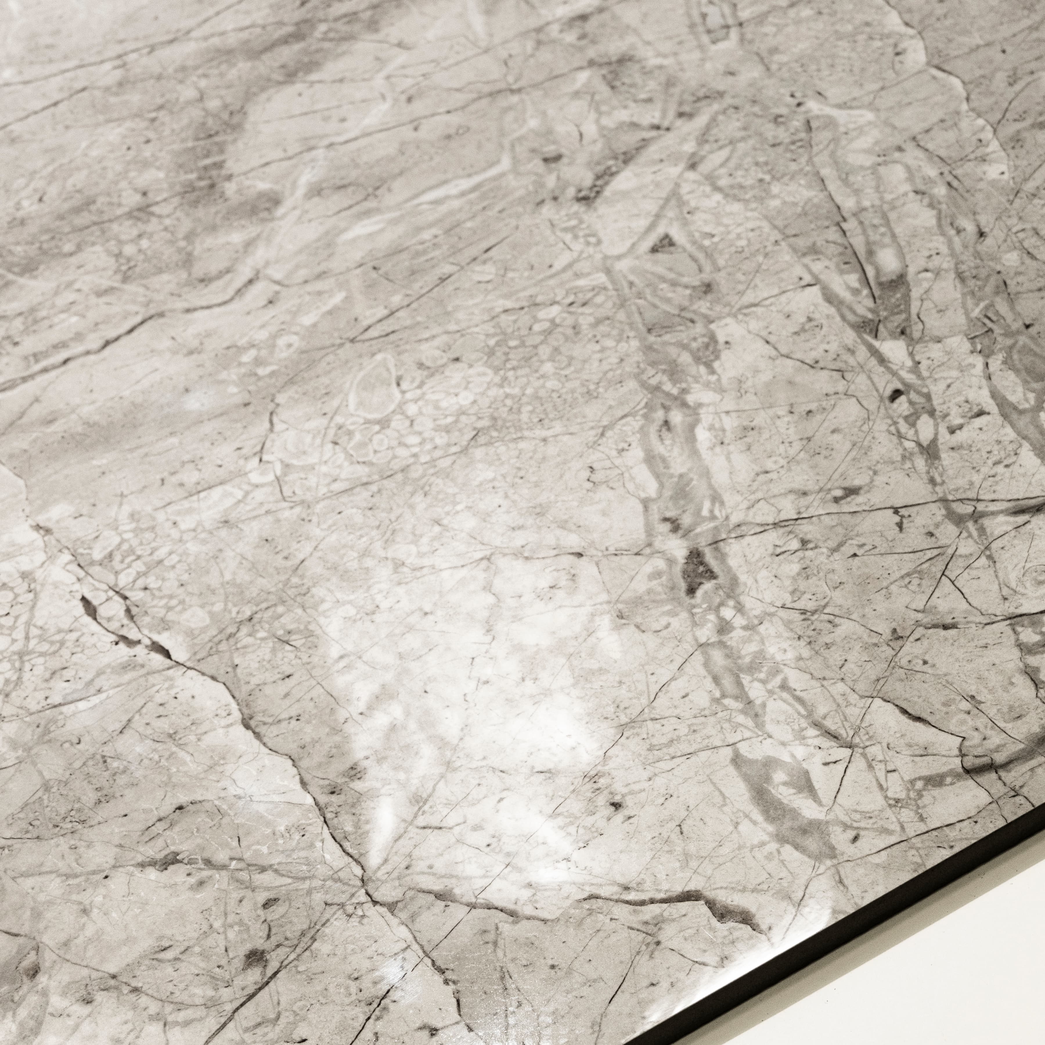 Close-up of Breccia Bianco glossy porcelain tile showing mirror-polished marble surface with detailed dark vein clusters and 9mm thickness.