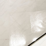 Close-up of Crema Onyx glossy porcelain tile showing mirror-polished cream onyx surface, gold vein detail, and 9mm thickness