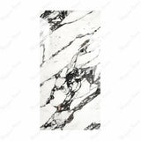 Impact Statuario porcelain slab displayed on easel against luxury backdrop showing crisp white marble surface with elegant grey veining for UAE interior design