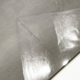Close-up of Portland Grey glossy porcelain tile showing mirror-polished warm grey cement-look surface and 9mm thickness
